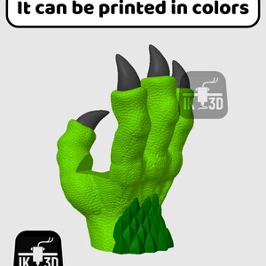 May include: A 3D printed green monster hand with black claws. The hand is posed with the fingers curled in. The text "It can be printed in colours" is at the top of the image.