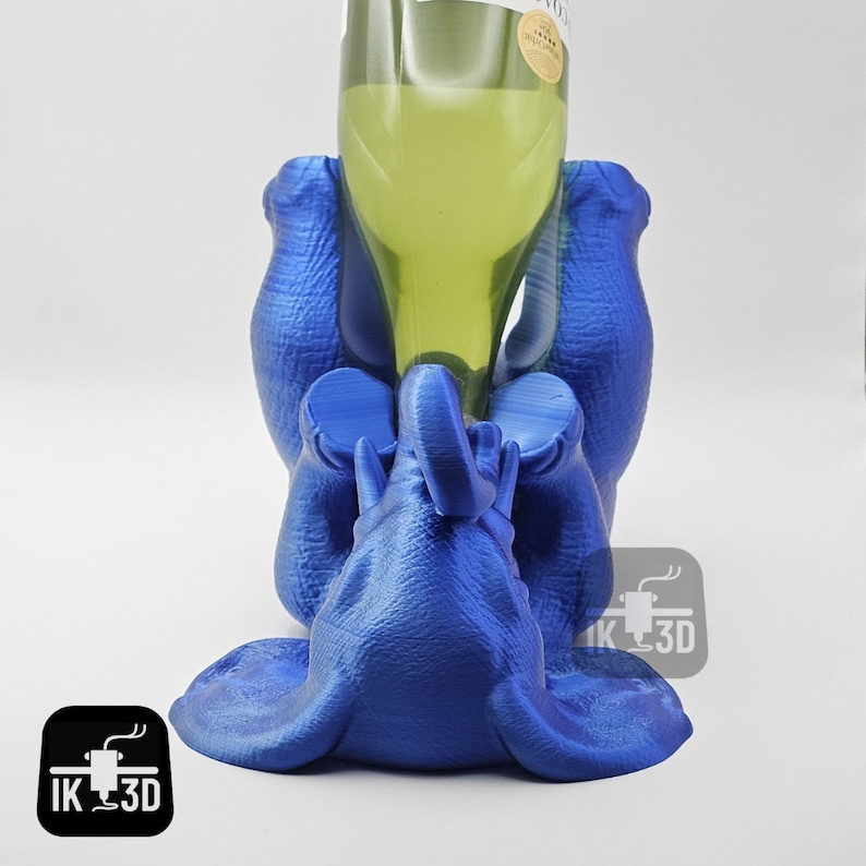 May include: A blue 3D printed elephant bottle holder with a wine bottle in its trunk.