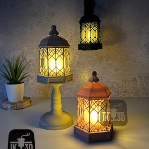 May include: Three 3D printed lanterns with a gothic design. The lanterns are lit with warm white LED lights. The lanterns are made of a light gray, dark gray, and brown plastic.