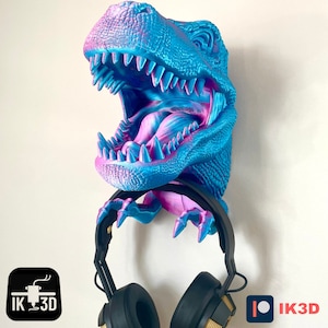 May include: A blue and pink dinosaur head wall mount with an open mouth and sharp teeth. The dinosaur head is holding a pair of black headphones.