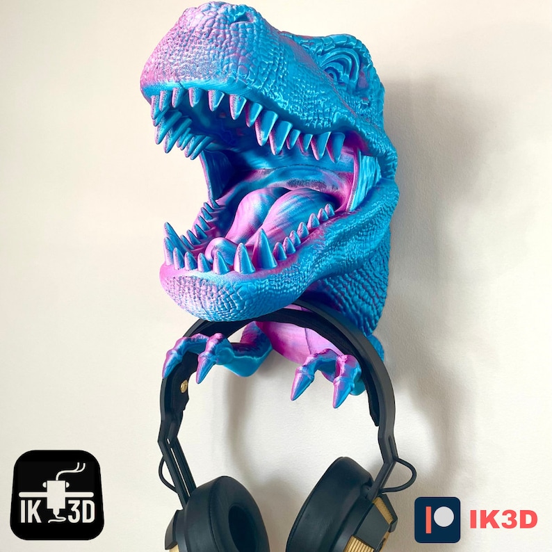 May include: A blue and pink dinosaur head wall mount with an open mouth and sharp teeth. The dinosaur head is holding a pair of black headphones.