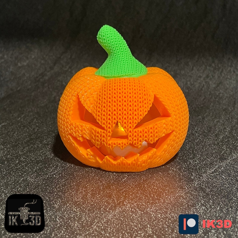 Pode incluir: Uma ab&oacute;bora laranja impressa em 3D com uma haste verde e um rosto de ab&oacute;bora esculpido. A ab&oacute;bora &eacute; iluminada por dentro, criando um brilho quente.