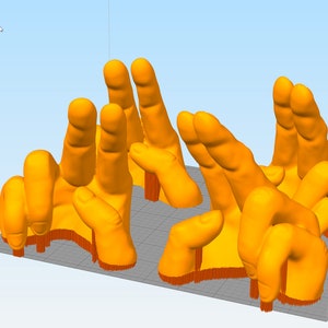 May include: Six 3D printed orange hands in various poses, printed on a gray platform.