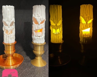 May include: Two white 3D printed candlesticks with a spooky face design. The candlesticks are lit and glowing yellow. The candlesticks are on a gold base and a brown base.