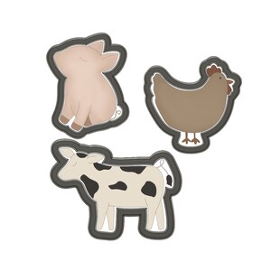K&ouml;nnte beinhalten: Drei Ausstecher in Form von Bauernhoftieren: ein Schwein, eine Kuh und ein Huhn. Das Schwein ist rosa, die Kuh ist schwarz-wei&szlig; und das Huhn ist braun.