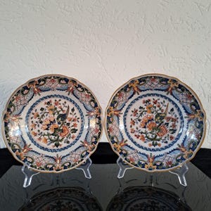Pair of Royal Tichelaar Makkum Delft polychrome of floral and bird decor wall plates