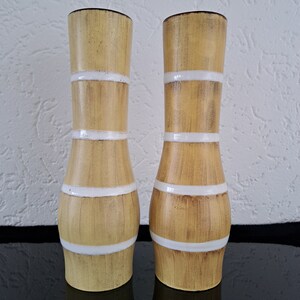 Op de afbeelding: Twee hoge, keramische vazen met een houtnerfpatroon en witte strepen. De vazen zijn lichtbruin.