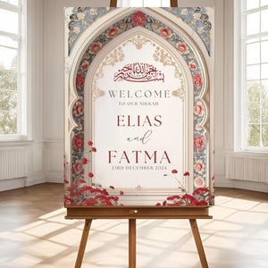 Op de afbeelding: Welkom bord met een bloemig boogontwerp in tinten rood, blauw en goud. Het bord luidt "Welkom op onze Nikkah Elias en Fatma 23 december 2024".