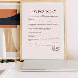 Peut inclure: Une impression encadrée avec un fond rose et du texte noir qui dit "JUST FOR TODAY" et comprend une liste d'affirmations sur la positivité corporelle et le soin de soi. Le texte comprend également la phrase "Life is too short to wait."