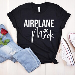 May include: Black t-shirt with white text that reads "Airplane Mode" with a small airplane icon.