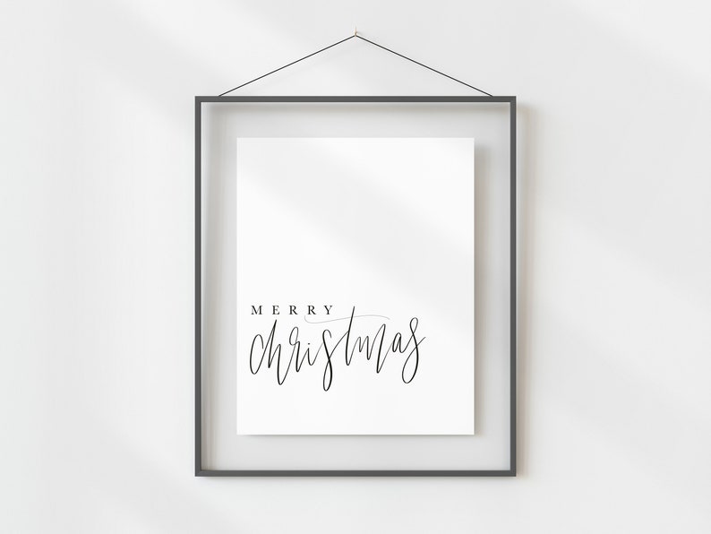 May include: A black framed print with the text "Merry Christmas" in a handwritten font.