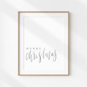 May include: A framed print with the text "Merry Christmas" in a simple black script font on a white background.