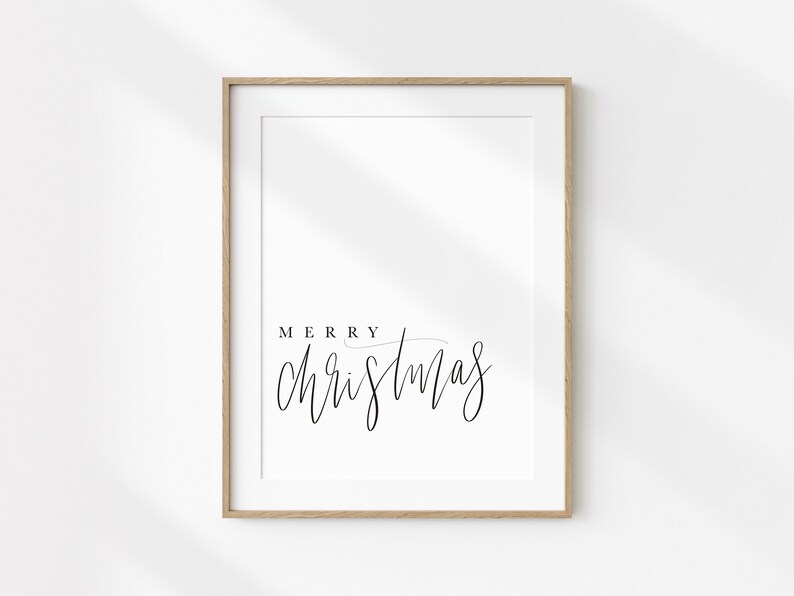 May include: A framed print with the text "Merry Christmas" in a simple black script font on a white background.