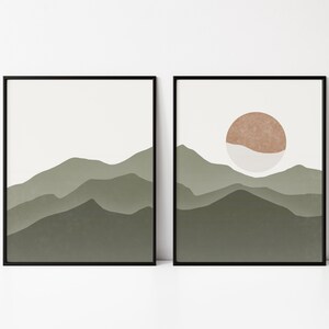 Op de afbeelding: Twee ingelijste prints met een minimalistisch ontwerp met een landschap van groene bergen. De print rechts heeft een bruine en witte cirkel in de lucht.