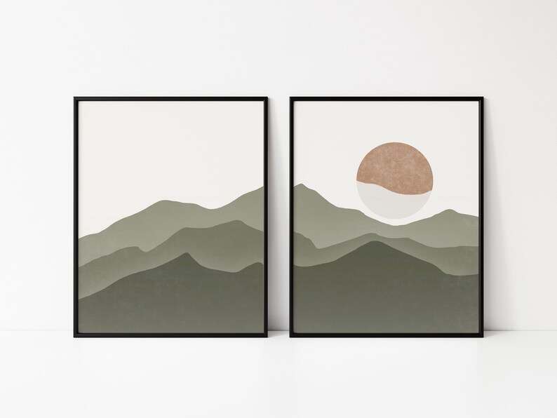 Op de afbeelding: Twee ingelijste prints met een minimalistisch ontwerp met een landschap van groene bergen. De print rechts heeft een bruine en witte cirkel in de lucht.