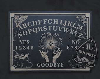May include: A black Ouija board and planchette. The board displays the alphabet, numbers, and the words "YES" and "NO". The planchette has the word "GOODBYE" and an eye symbol. Decorative illustrations of bats, birds, and clouds adorn the board.