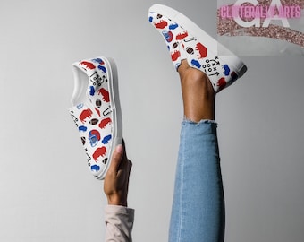 May include: White slip-on shoes with a repeating pattern of red and blue football-themed graphics. The design includes footballs, helmets, and buffalo silhouettes. The shoes are held up against a white background.