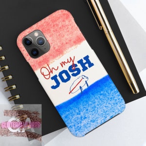 Può includere: Una custodia per telefono bianca con un design ad acquerello rosso, bianco e blu. Il testo "Oh my JOSH" è scritto in lettere blu sulla custodia. Un maiale stilizzato è disegnato in rosso sulla custodia.