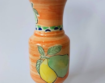 Könnte beinhalten: Eine Keramikvase mit hellorangefarbenem Hintergrund und einem bemalten Design aus Zitronen und Blättern. Die Vase hat einen blauen Rand und ein blaues und grünes Band um die Mitte.