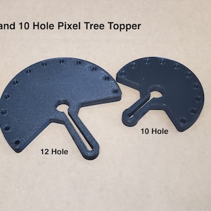 May include: Two black plastic tree toppers with 12 and 10 holes for lights. The larger topper has 12 holes and the smaller topper has 10 holes. Both toppers have a slot in the center for a tree trunk.