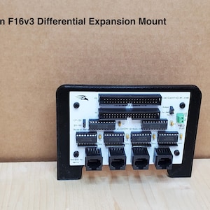 May include: A black Falcon F16v3 Differential Expansion Mount with a white label that says "FalconChristmas.com" and "FalconController.com". The mount has four RJ-45 connectors, a 40-pin header, and a 32-pin header.