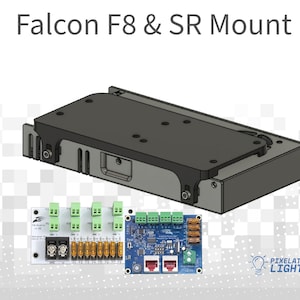 May include: A black metal mount for Falcon F8 and SR lights. The mount has a rectangular shape with a flat top and a raised edge. The mount is designed to be attached to a surface. The image also shows two circuit boards with green and blue connectors. The circuit boards are labeled "Pixelated Lights".