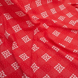 May include: A vibrant red fabric featuring a repeating checkered pattern. The design alternates between squares filled with small white five-petaled flowers and squares containing a delicate white floral line art pattern with tiny white dots.