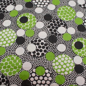 May include: A fabric featuring a dense pattern of overlapping circles in varying sizes. The design consists of solid black, solid white, and solid lime green circles, along with larger circular motifs filled with smaller polka dot patterns in these colors.