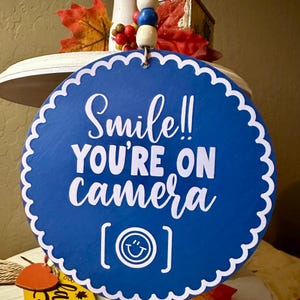 Smile You&#39;re On Camera Türschild: Blaues Holz Mini Akzentschild