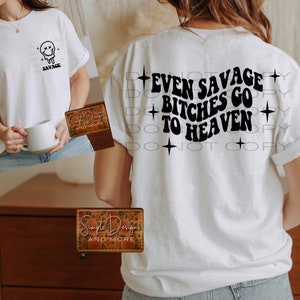 May include: White t-shirt with a black graphic that says "Even Savage Bitches Go To Heaven" with stars on either side of the text. The shirt is being modeled by a person.