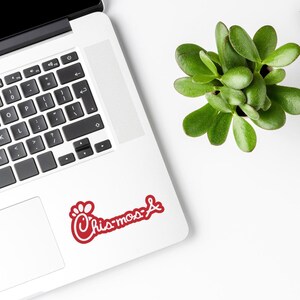 May include: A red and white Chick-fil-A logo sticker on a silver laptop.