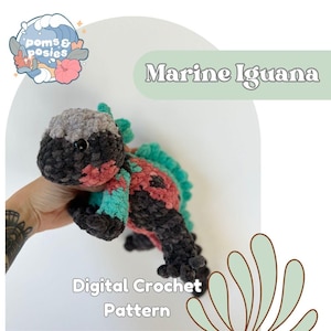 May include: A handmade crochet iguana in shades of gray, black, red, and teal. The iguana has a textured, plush appearance. The image includes the text "Marine Iguana" and "Digital Crochet Pattern".