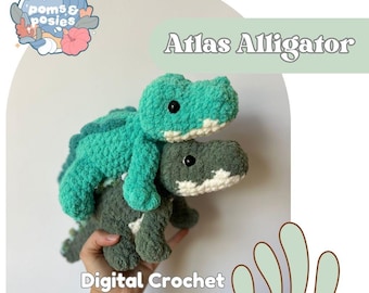 May include: Two crocheted alligator plushies, one teal and one grey, stacked. The top alligator is teal with a white belly, and the bottom alligator is grey with a white belly. The text "Atlas Alligator" and "Digital Crochet Pattern" are also visible.