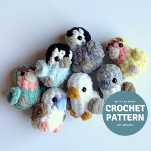 May include: A collection of crocheted seabird amigurumi toys in various colors, including pink, yellow, blue, white, and gray. The toys are arranged on a white background with a blue circle that says "Bitty Sea Birds Crochet Pattern PDF English".