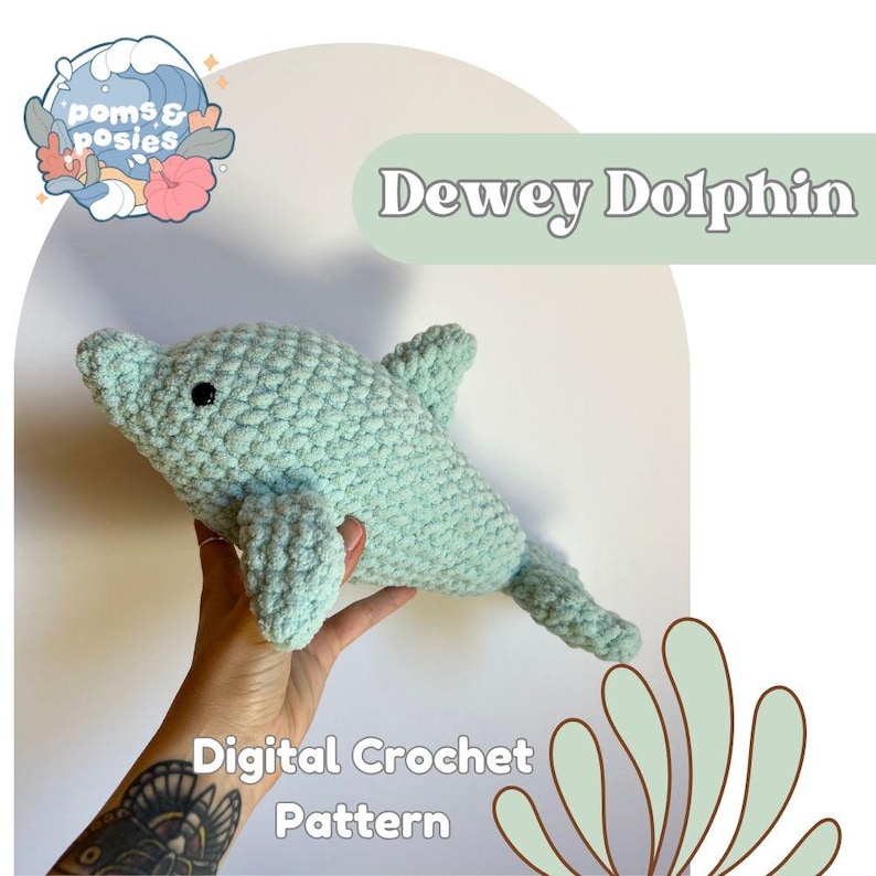 May include: A crochet pattern for a light blue dolphin amigurumi toy. The pattern is called "Dewey Dolphin" and is a digital download.