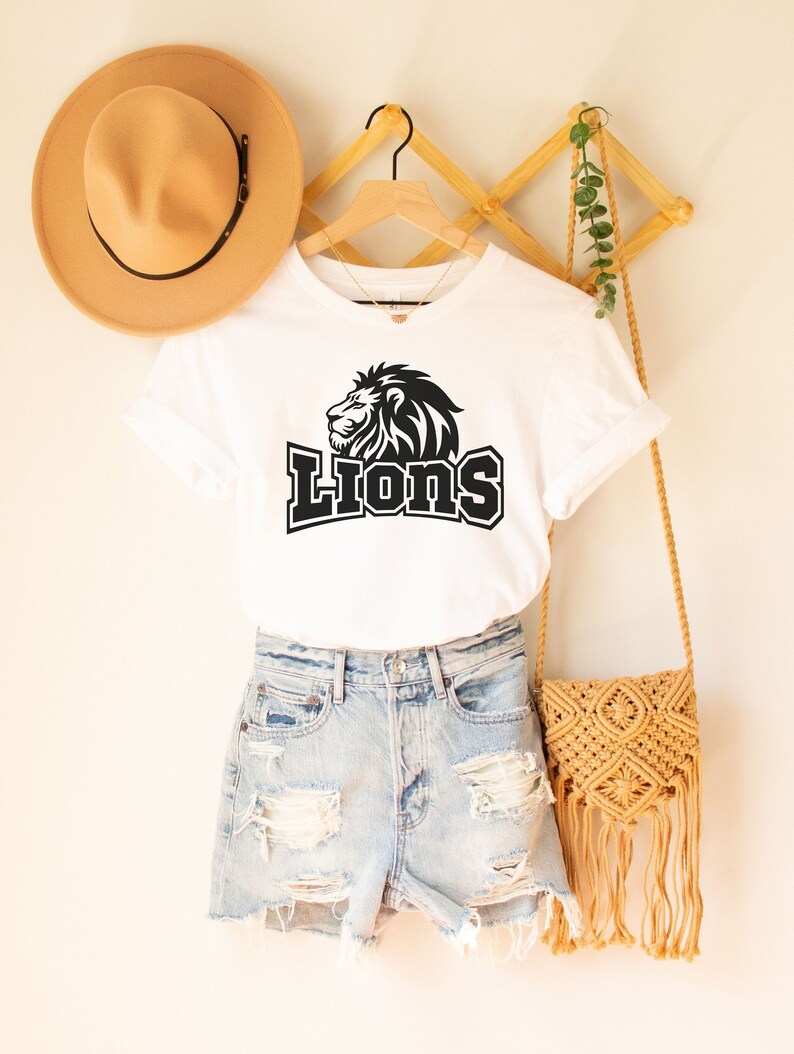 May include: White t-shirt with a black lion graphic and the word "LIONS" in black text.