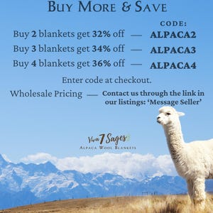 a white llama standing in a field with mountains in the background