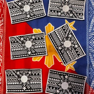 Puede incluir: Cinco parches bordados en blanco y negro de la bandera filipina con un diseño tribal tradicional. Los parches están sobre un fondo rojo, blanco y azul.