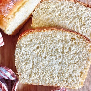 Op de afbeelding: Close-up van een gesneden witbrood. Het brood heeft een zachte, luchtige textuur en een licht goudbruine korst.