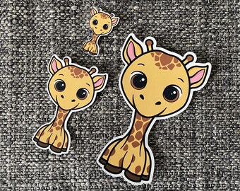 May include: Three cartoon giraffe stickers with brown spots and pink ears. The largest giraffe is smiling with big eyes. The smallest giraffe is standing upright with its neck extended.
