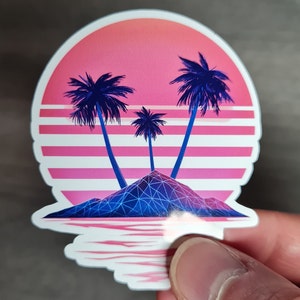 Pu&ograve; includere: Un adesivo con un tramonto in stile retr&ograve; sopra una piccola isola con tre palme. L'isola &egrave; una forma geometrica con linee blu e viola. Il tramonto &egrave; rosa e arancione con strisce bianche.