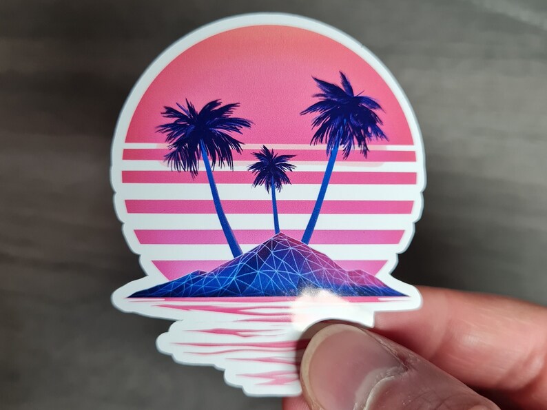 Pu&ograve; includere: Un adesivo con un tramonto in stile retr&ograve; sopra una piccola isola con tre palme. L'isola &egrave; una forma geometrica con linee blu e viola. Il tramonto &egrave; rosa e arancione con strisce bianche.