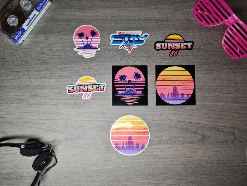 Pu&ograve; includere: Sei adesivi in stile retr&ograve; con disegni di tramonto e palme. Gli adesivi presentano una combinazione di colori rosa, arancio e blu con il testo "Sunset 86" e "Stay Rad" su due degli adesivi.