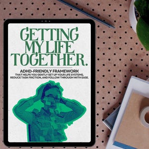 Puede incluir: Una tableta muestra el texto "GETTING MY LIFE TOGETHER." con el subtítulo "ADHD-FRIENDLY FRAMEWORK." La imagen presenta una ilustración verde y azul de una persona. También se ven un bolígrafo, una planta y cuadernos.