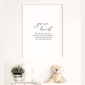 Peut inclure: Une impression encadr&eacute;e blanche avec le texte "you are loved" et le texte suivant en dessous : "for the boy you are, the man you will become, and the precious son you will always be."