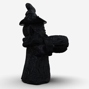 K&ouml;nnte beinhalten: Eine schwarze, strukturierte Holzfigur eines Zauberers, der einen Kessel h&auml;lt. Der Zauberer tr&auml;gt einen spitzen Hut und eine lange, flie&szlig;ende Robe.