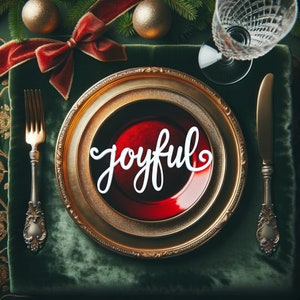 May include: A gold-rimmed plate with a red and gold design. The plate has a white word "joyful" on top of a red background. The plate is on a green velvet surface with a gold fork and knife.