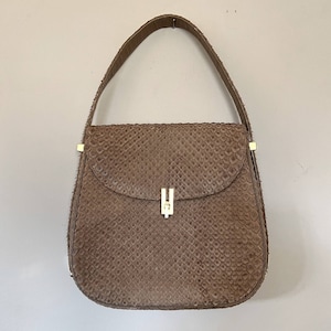 May include: A brown snakeskin shoulder bag with a gold clasp. The bag has a flap closure and a single strap.