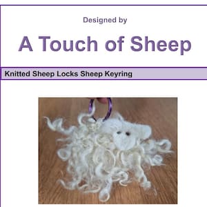 May include: A white sheep keyring with a fluffy wool body and a small, white face. The keyring has a purple metal ring. The text "Designed by A Touch of Sheep" and "Knitted Sheep Locks Sheep Keyring" are visible.