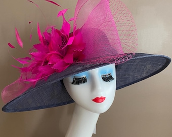 May include: A navy blue wide-brimmed hat with a pink feather and mesh trim.